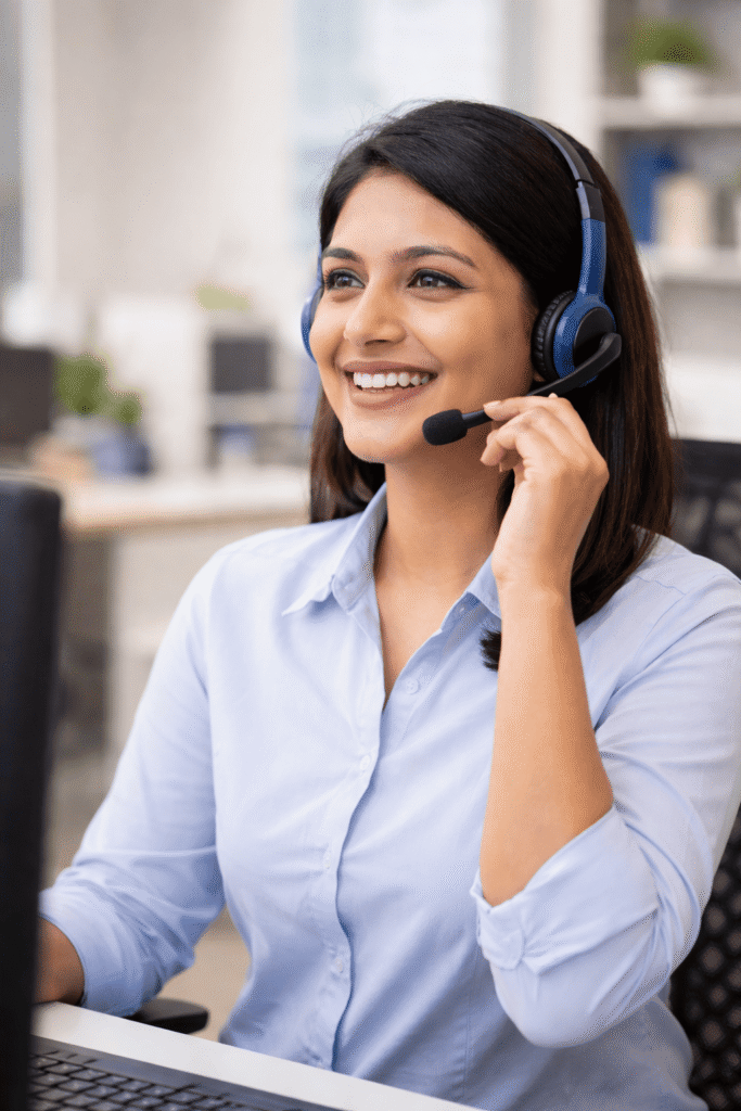 Smiling customer support executive wearing a headset and talking to customers from an office in Kolkata